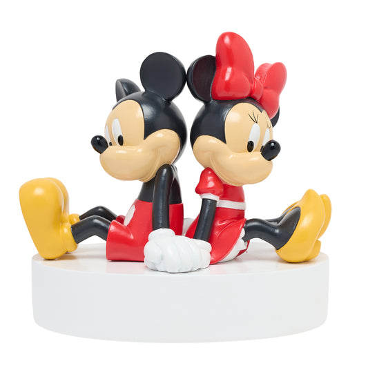 Spaarpot met iconisch Disney duo op een witte voet, ruggen naar elkaar terwijl ze elkaars hand vasthouden, symbool van romantiek en vriendschap.