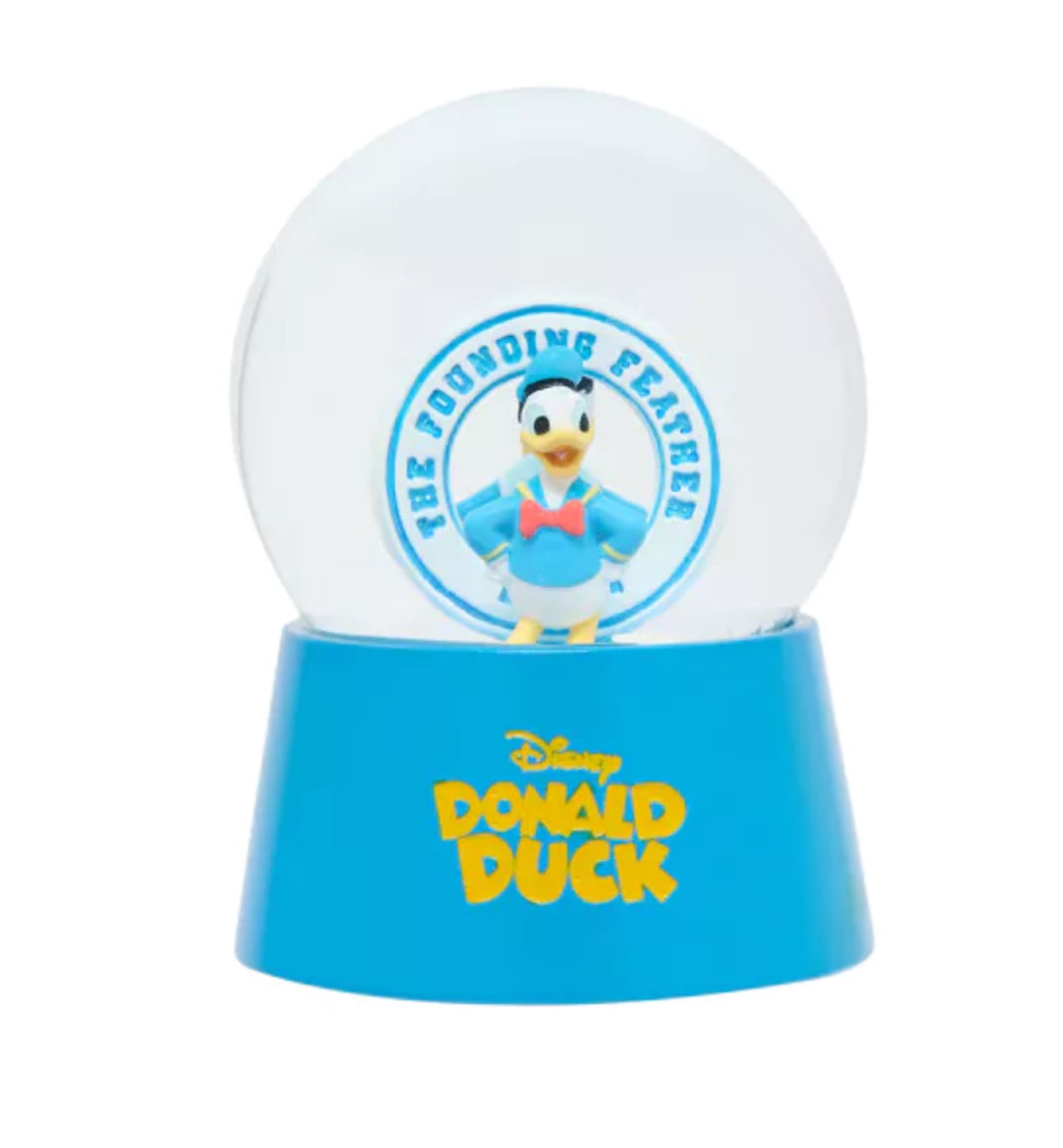 Disney Donald Duck sneeuwbol met twee figuren in verschillende outfits, een officieel gelicenseerd product dat vreugde en nostalgie brengt bij elke schudbeweging.