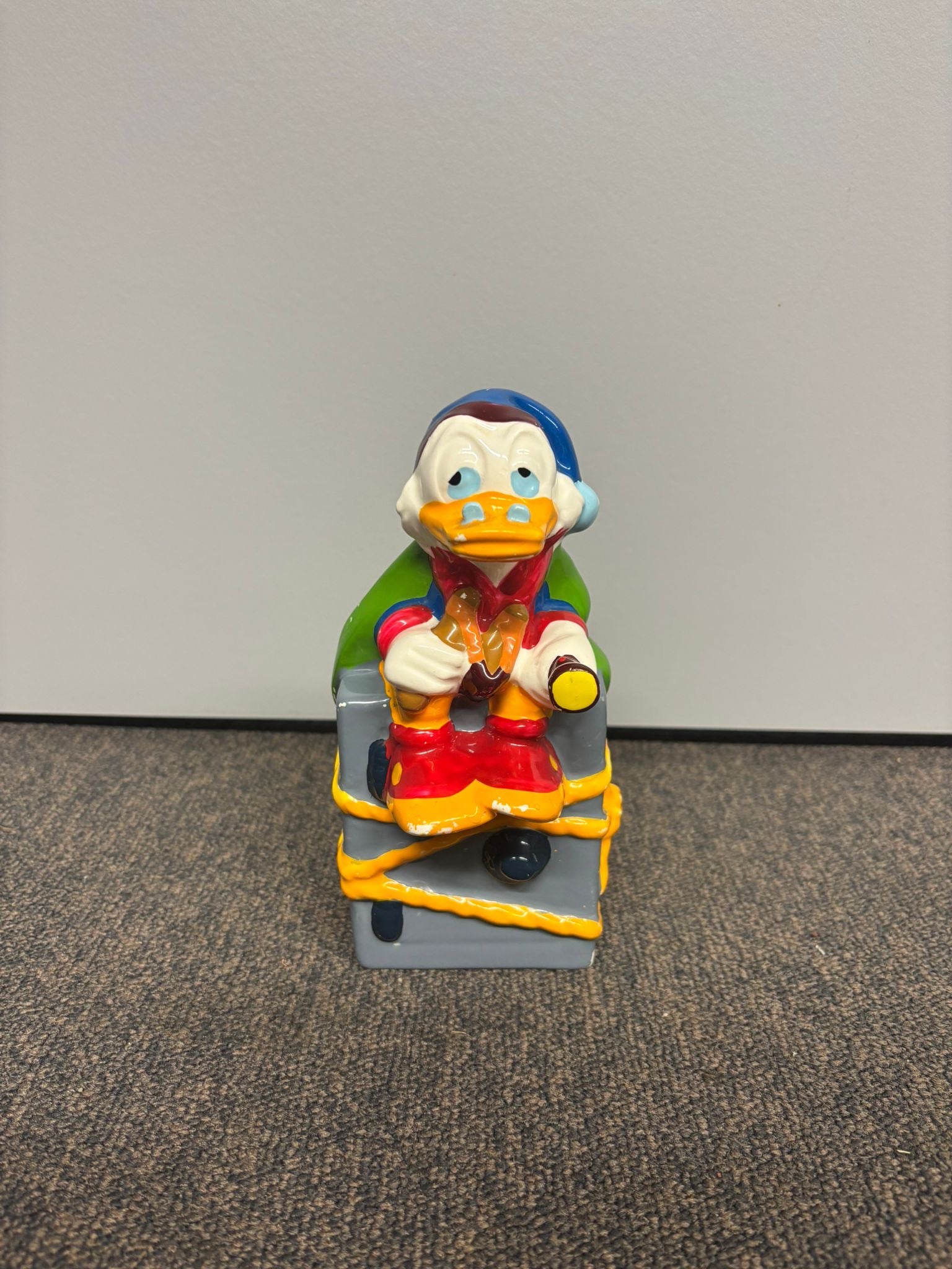 Disney Dagobert Duck spaarpot ‘Bewaakt de Kluis’, met gedetailleerd ontwerp en de iconische miljonairseend die zijn kluis beschermt.