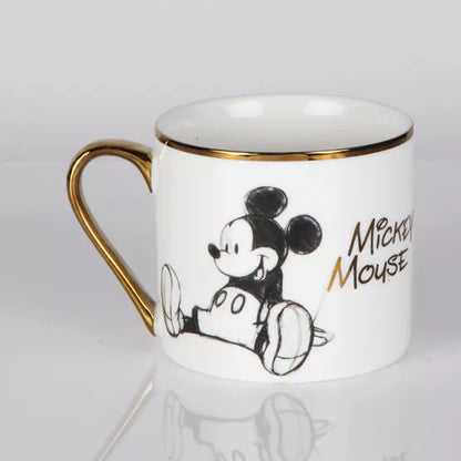 Mok verpakt in een zwart en goud foliedoos, ideaal als geschenk voor Disney-enthousiastelingen.